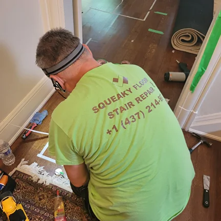 Squeaky Floor & Stair Repairs technician repairing a squeaky hardwood floor in a GTA home